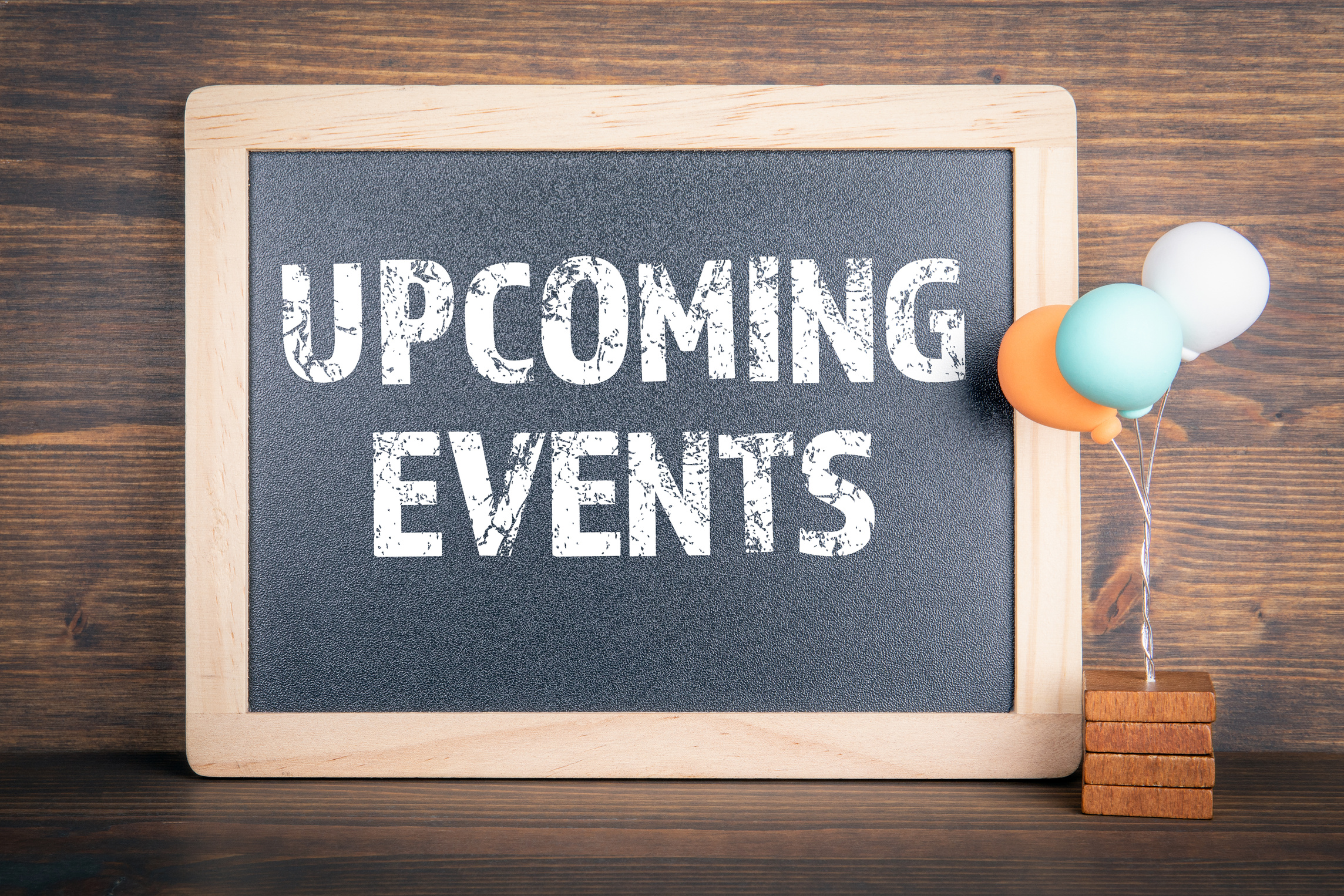 UPCOMING EVENTS. Chalkboard and colored balloons on a wooden background